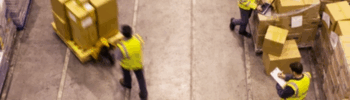 Trabajadores en un almacén logístico gestionando mercancía mientras se evalúa el absentismo laboral