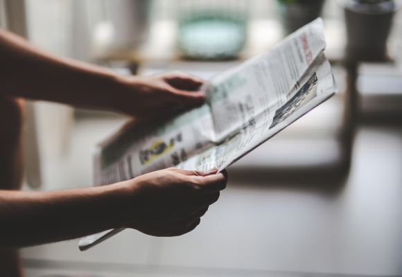 Persona leyendo el Diario Vasco con mención a Investigaciones Nor en Donostia