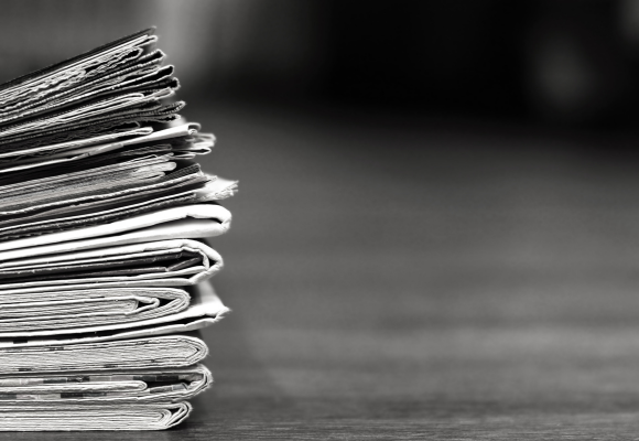 Pila de periódicos representando la aparición de Investigaciones Nor en Noticias de Gipuzkoa